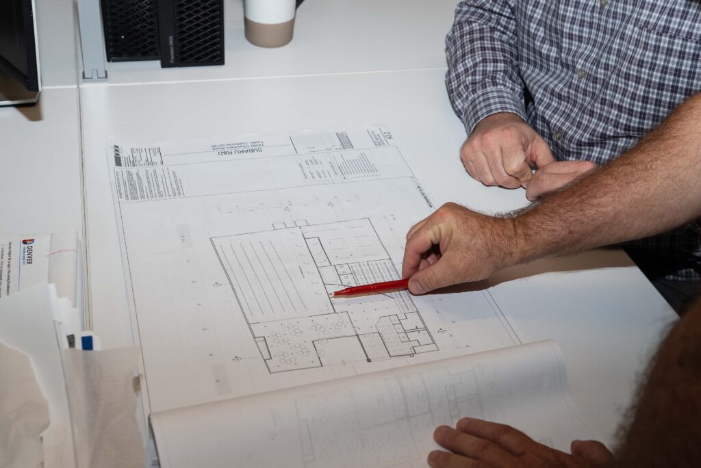 Two members of the ADC team working on a blueprint design, the perfect metaphor for what you have the opportunity to do for your career after architecture school!