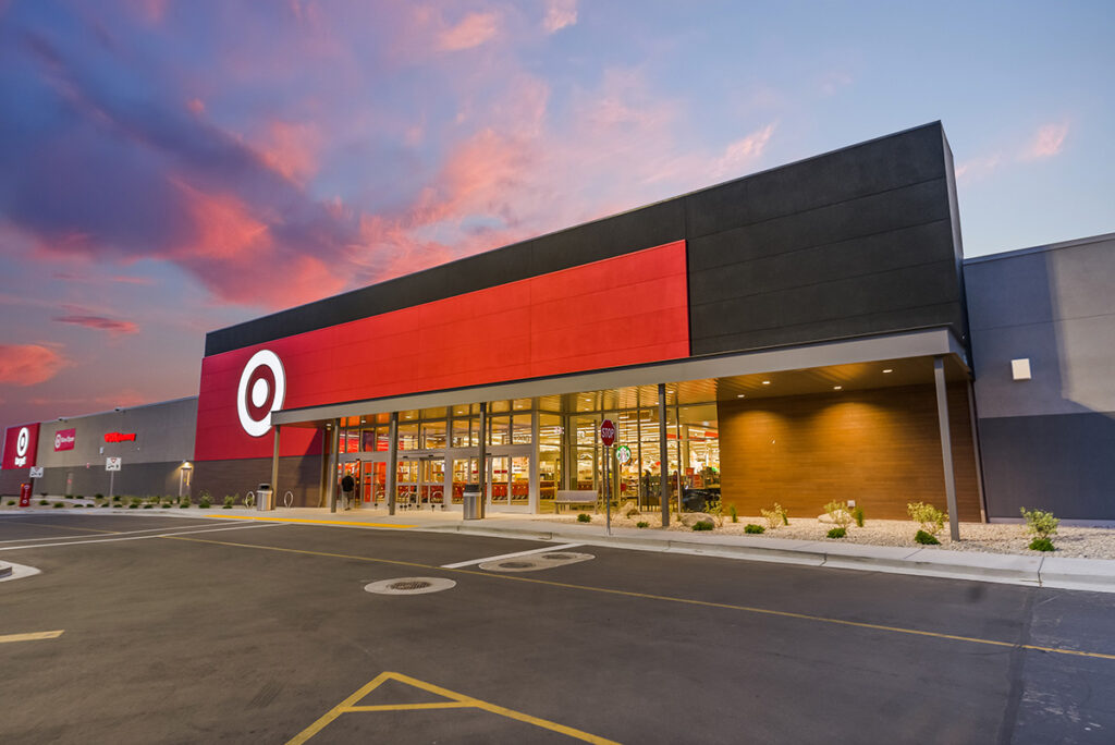 Exterior of a Target store at dusk with a prominent red Target logo above the entrance and a colorful sky in the background.