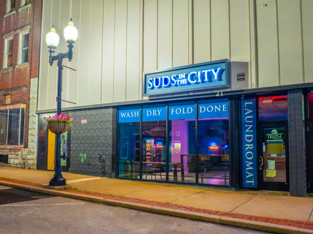 Suds in the City PA laundromat in Greensburg storefront exterior bright sign historic downtown community laundry service welcoming clean design