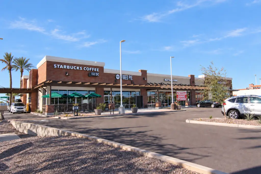 Multi-tenant retail building at Mesa Riverview in Mesa, Arizona, featuring brick storefronts, shaded walkways, and shell architecture by Architecture Design Collaborative.