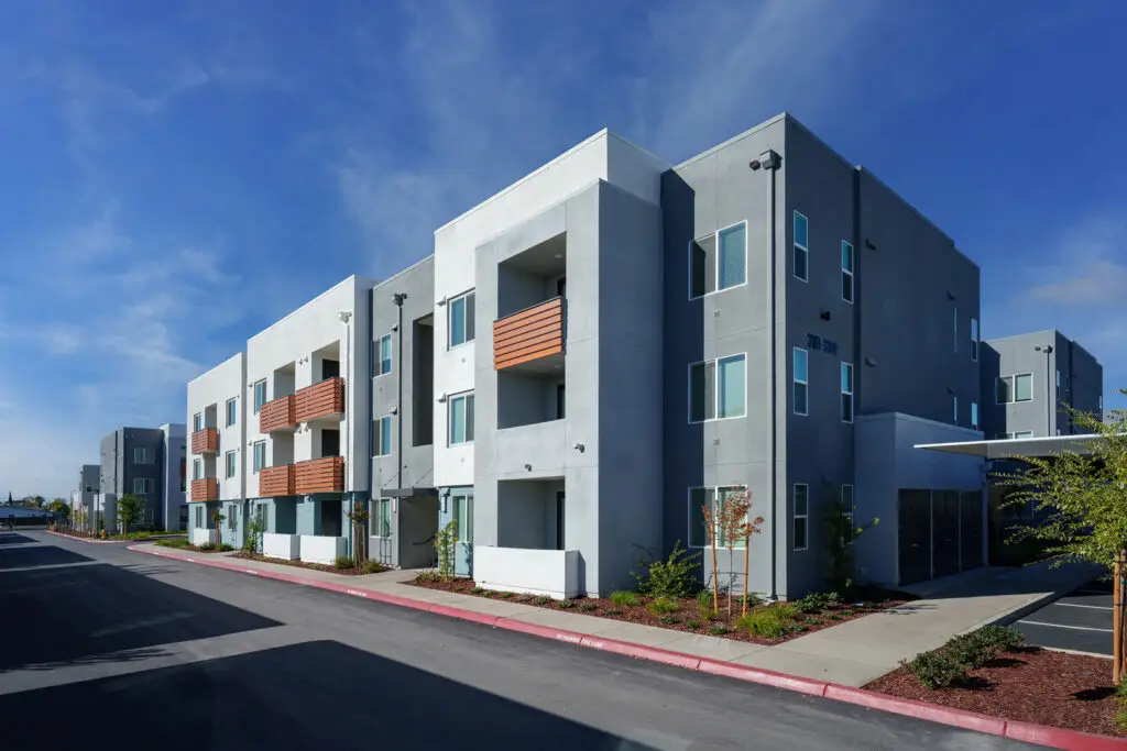 Anton Mosaic affordable housing community in Sacramento with contemporary three-story apartment buildings and landscaped pedestrian frontage