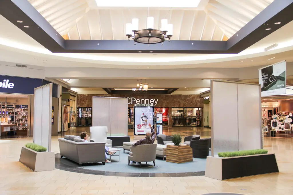 Renovated seating area at Coastland Center in Naples with custom privacy screens and furniture designed by Architecture Design Collaborative