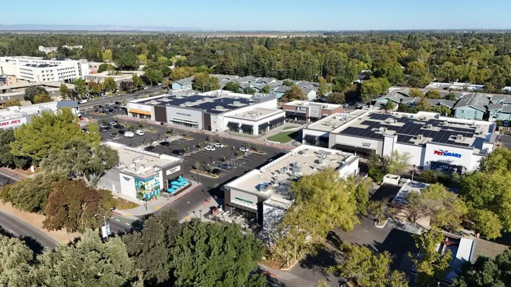 Aerial view of The Davis Collection in Davis, with new retail buildings, rooftop solar, parking, and Trader Joe’s at the street edge