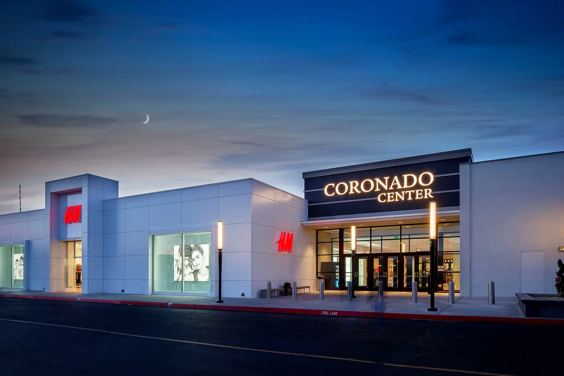 Night exterior of H&M and the Coronado Center entrance in Albuquerque, designed by Architecture Design Collaborative