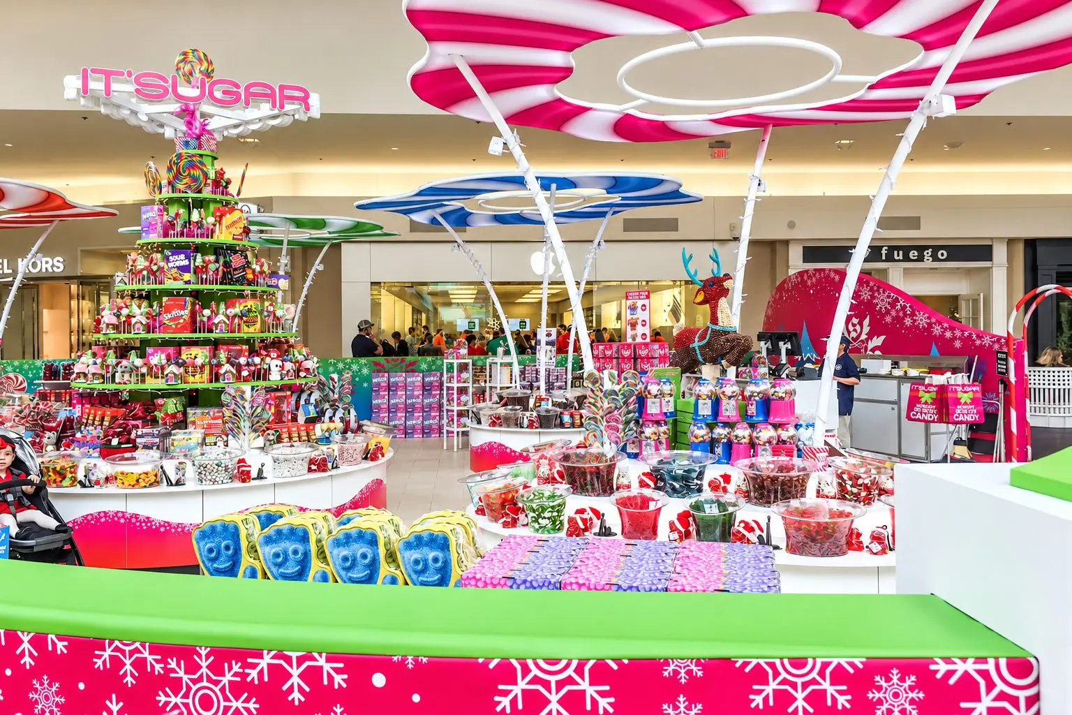 IT'SUGAR holiday candy kiosk at Baybrook Mall in Friendswood, Texas with colorful displays, oversized candy canopies, and seasonal graphics