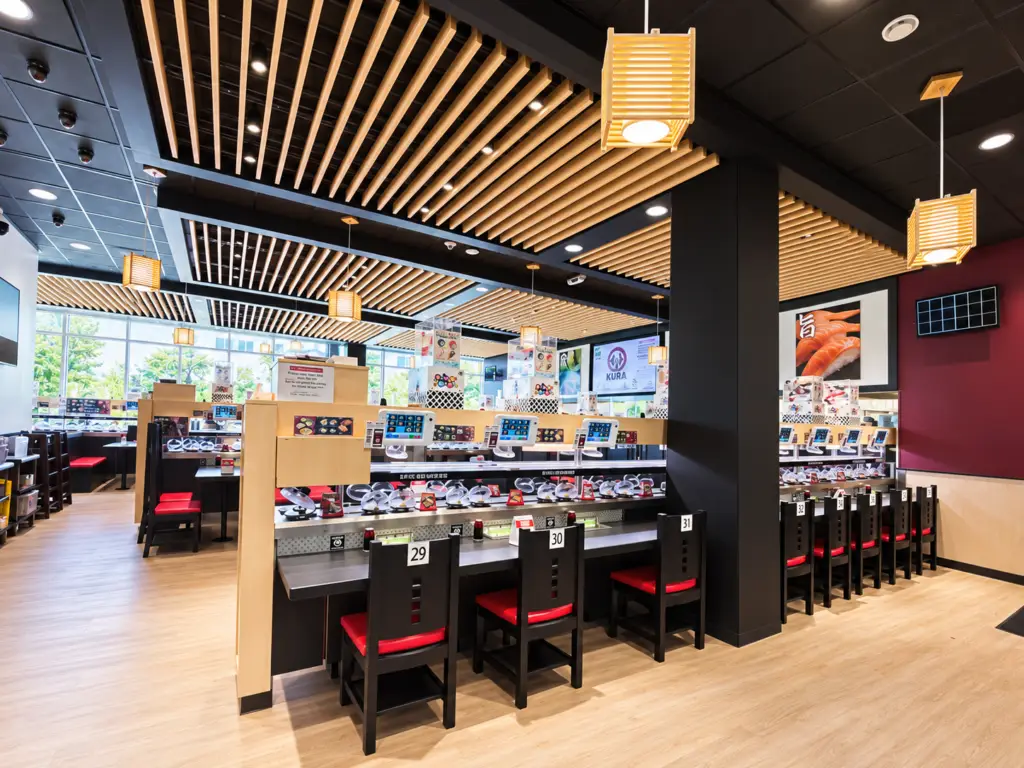 Kura Sushi in Bellevue, Washington, featuring revolving sushi dining, wood ceilings, and technology-integrated restaurant design by Architecture Design Collaborative.