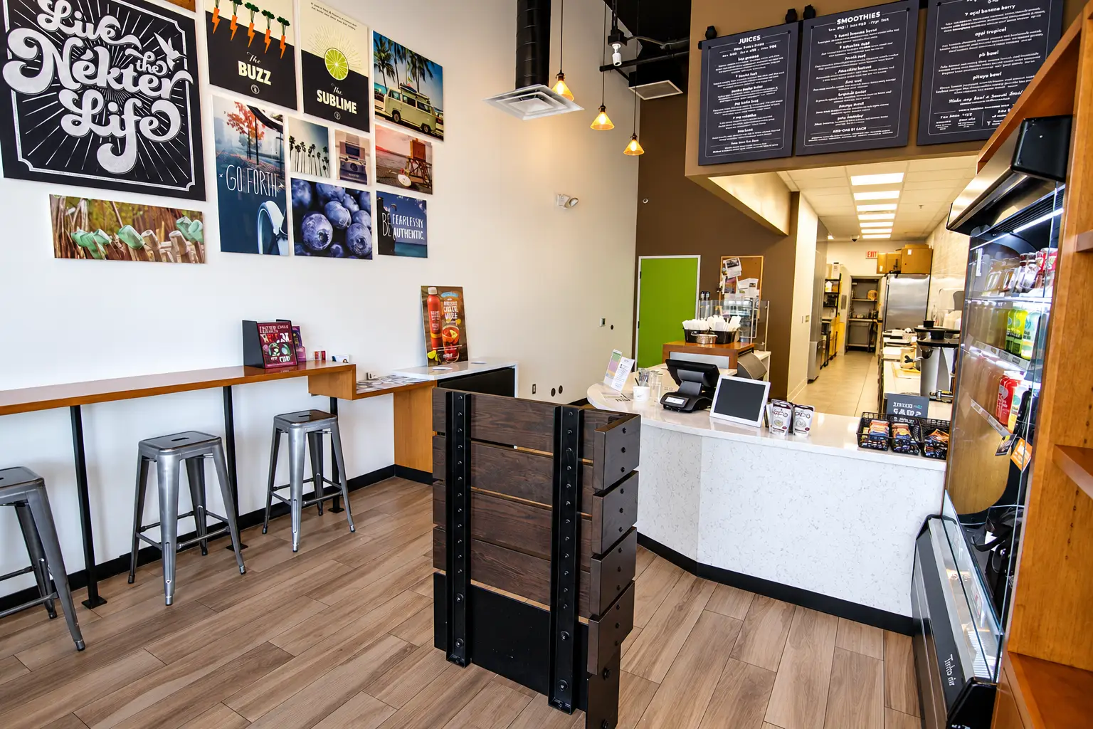 Nékter Juice Bar interior in Las Vegas with customer seating and branded wall graphics, designed by Architecture Design Collaborative