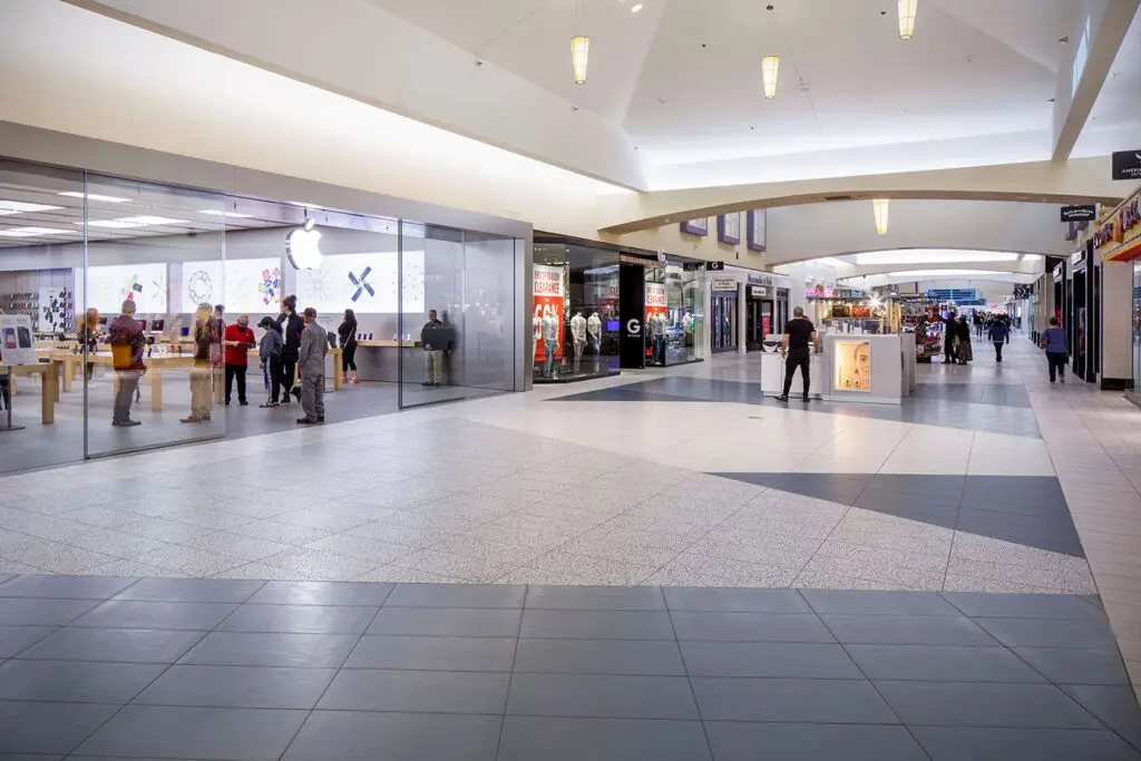 Renovated corridor at Valley Plaza in Bakersfield with new geometric flooring leading past the Apple store