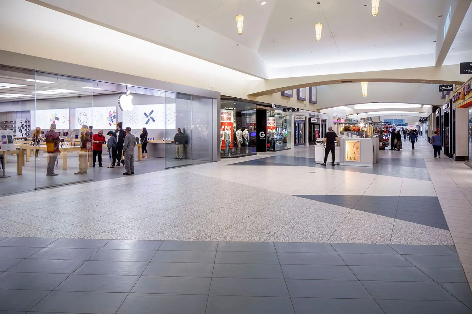 Renovated corridor at Valley Plaza in Bakersfield with new geometric flooring leading past the Apple store