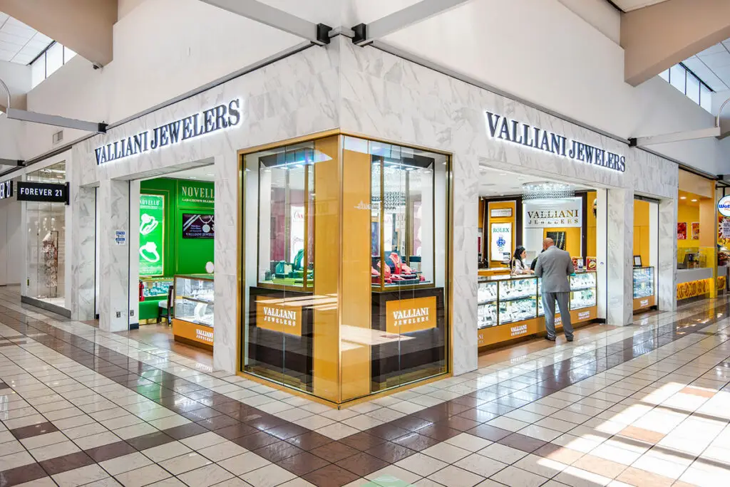 Corner mall storefront of Valliani Jewelers in Stockton, with marble surrounds, gold display windows, and halo-lit signage