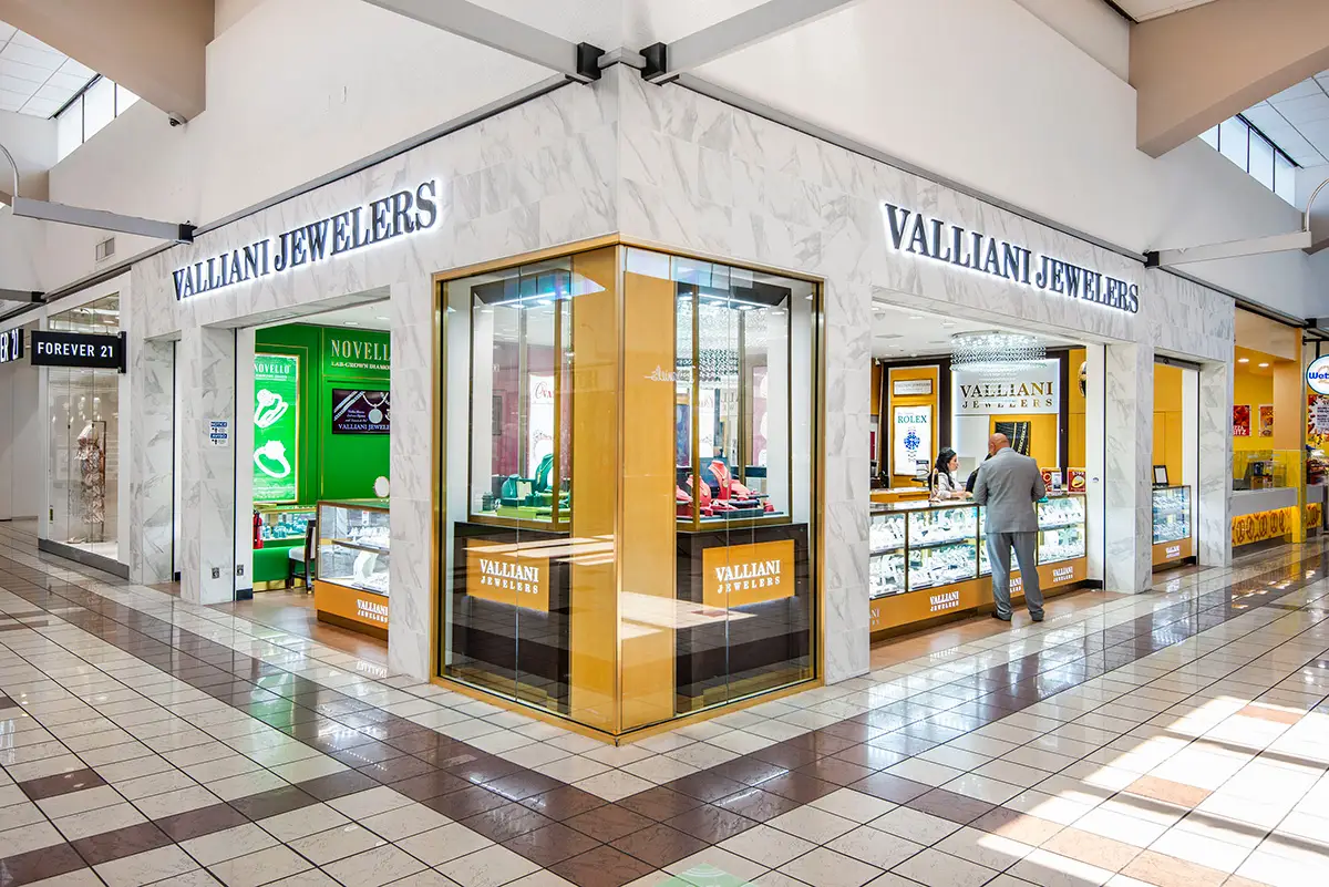 Corner mall storefront of Valliani Jewelers in Stockton, with marble surrounds, gold display windows, and halo-lit signage