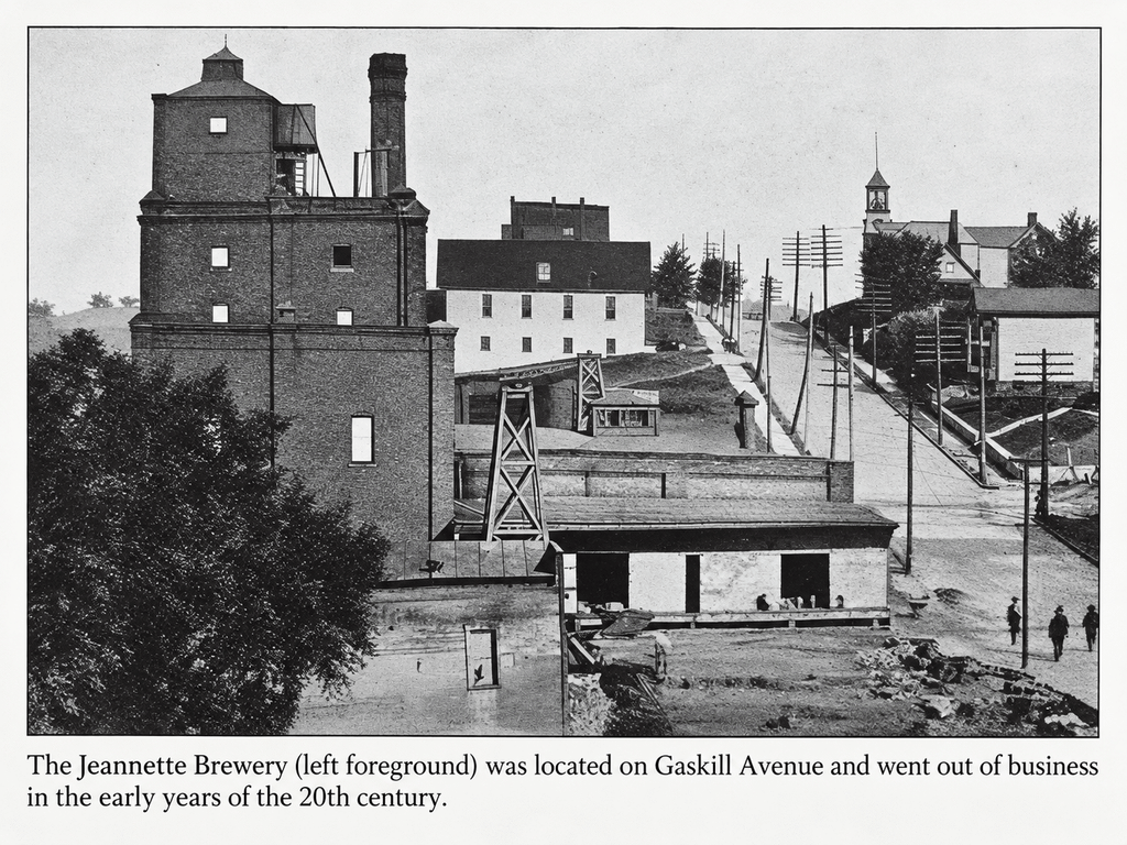 Historic photograph of the Jeannette Brewery on Gaskill Avenue, a brick industrial complex in the left foreground, with the printed caption noting it went out of business in the early years of the 20th century.